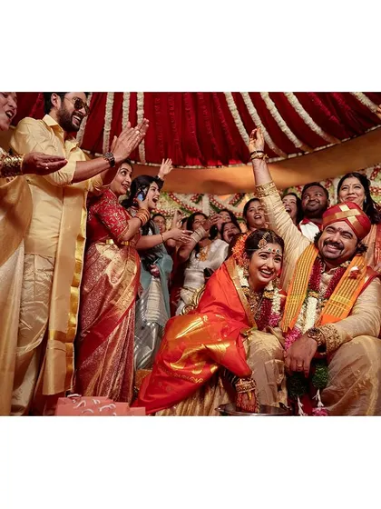 A moment of pure celebration and victory as the couple completes their wedding rituals, surrounded by cheering family and friends.