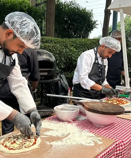 My team in action at the Adidas corporate event. The setup includes a red-and-white checkered tablecloth and a large prep area for making multiple pizzas at once.