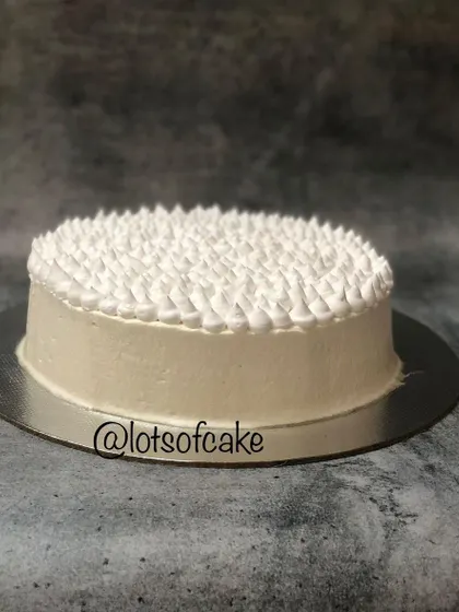 Sometimes, simple is best. This is a classic eggless vanilla cake with a clean, white buttercream frosting, perfect for any occasion that calls for a simple, elegant dessert.