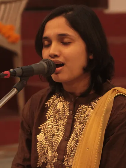 A student in a state of complete surrender to the music during her bhajan performance.