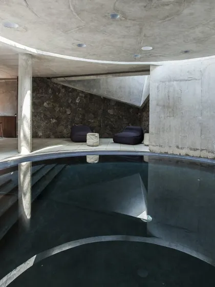Another view of the Hamam at K-Lagoon, showing the interplay of raw concrete, local stone, and water. The space is designed to be a sensory experience.