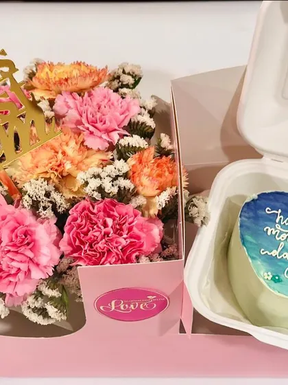 A heart-shaped bento cake with a hand-painted ocean theme for Mother's Day. This is paired with a 'World's Best Mom' flower arrangement, showing our custom art capabilities.