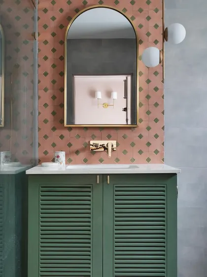 This bathroom from the Madras Home features a playful mix of terracotta and green patterned tiles with a louvered green vanity. It's a great example of using color and pattern in a small space.