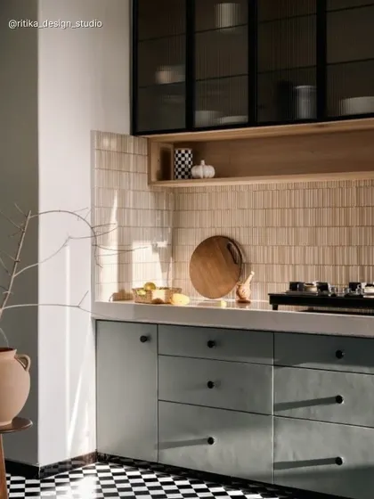 We gave this kitchen a modern-retro vibe with bold checkered flooring. The muted green cabinets are paired with a textured tile backsplash and black-framed glass overhead units, creating a space with lots of personality and warmth.
