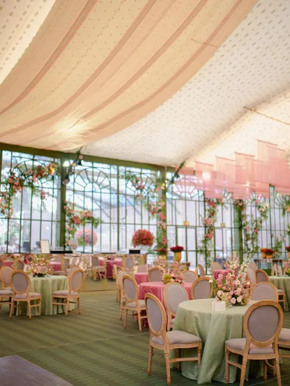 The airy and elegant reception space, set within a beautiful glasshouse structure. We used a palette of soft pinks and greens to create a serene and romantic atmosphere.