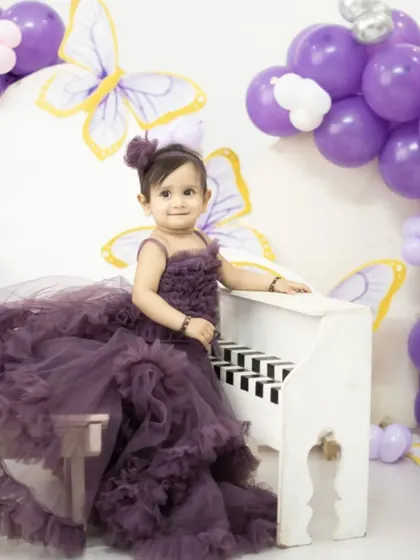 Planning a pre-birthday shoot for your little one? This grand purple ruffle gown will make your little angel feel like a fairytale princess. Available to rent or buy.
