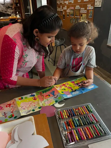 I love providing one on one guidance to help a young artist bring their vision to life. Here, a student gets some help with her colorful creation during our summer camp's artist book making session.