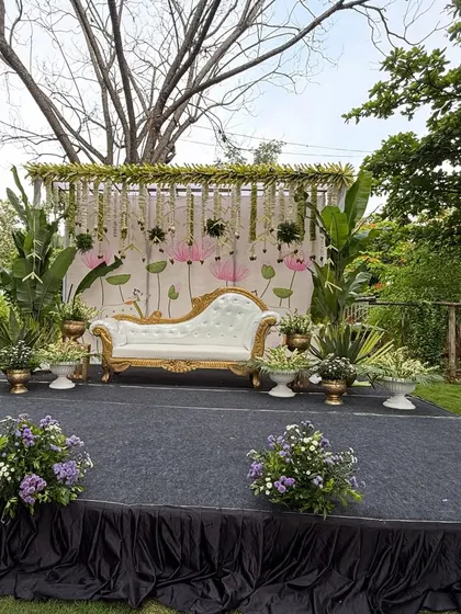 A full stage view of the outdoor Pichwai-themed baby shower. The open-air setting adds a natural and serene touch to the traditional decor.