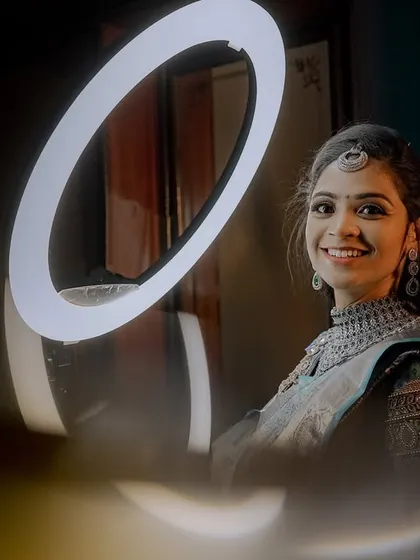 A happy smile from the bride during her reception getting-ready session. The lighting highlights the flawless finish of her makeup and the sparkle of her diamond jewelry.