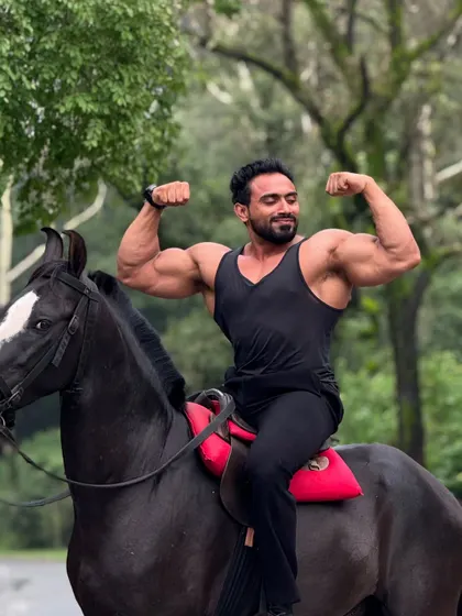Hitting a double biceps pose while on horseback.