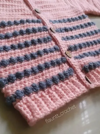 A close-up of the bobble stitch texture on the Dewdrops Cardigan. This detail adds a wonderful tactile element and extra warmth to the sweater.