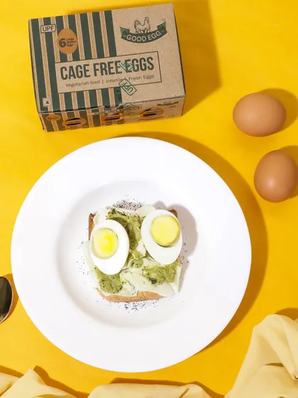 A fun and playful food styling concept, with boiled eggs creating a face on a piece of toast. This whimsical approach is designed to be memorable and shareable on social media platforms.