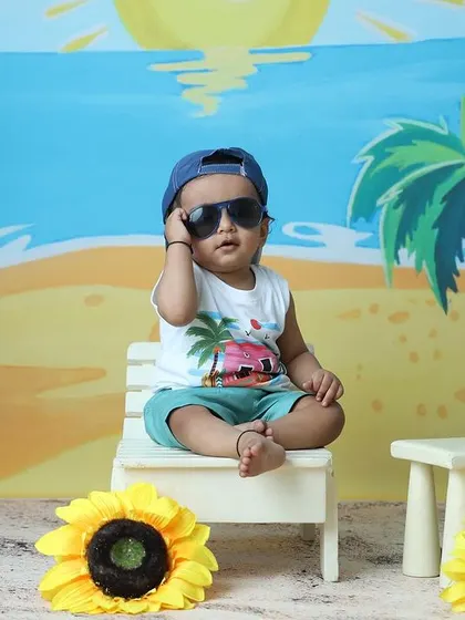 This little model strikes a cool pose with sunglasses during his beach-themed studio session.