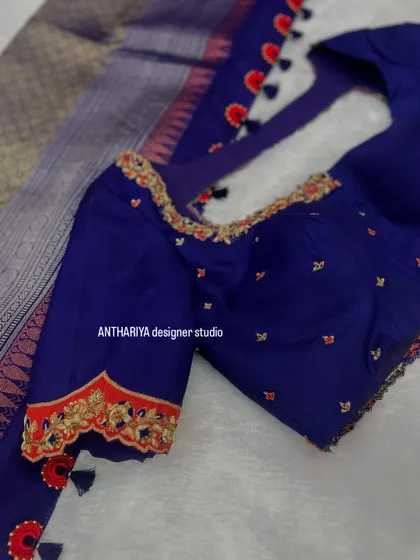 A classic navy blue blouse with a contrasting red embroidered border on the sleeves.