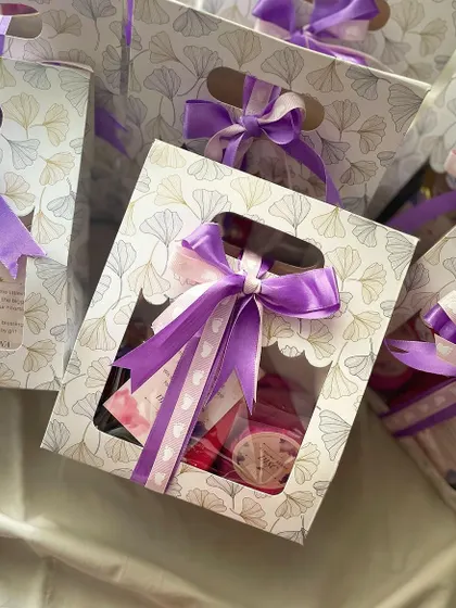 Announcing the arrival of a baby girl with our cute mini hampers. Each bag is filled with sweet treats and tied with a purple ribbon to share the joy.