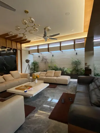 The spacious living room in Mr. Satish's residence is designed for large gatherings, with multiple seating zones unified by a consistent material and color palette.