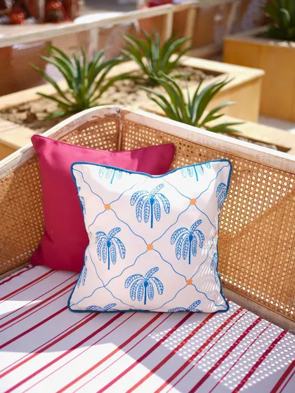 A custom-printed cushion with a palm tree motif, adding to the relaxed, playful vibe of the post-party lunch.