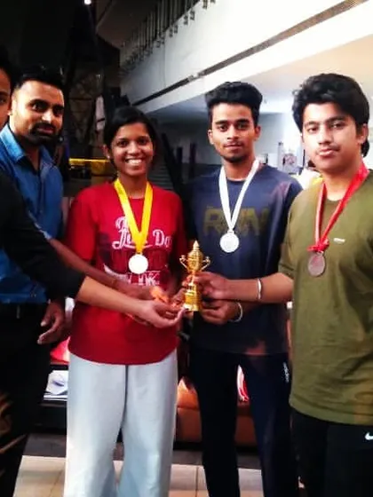 Celebrating a victory with our students. Our team proudly displays their medals and trophy after a successful competition, a result of their hard work and dedication in training.
