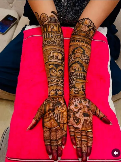 A full narrative on both arms. This intricate design includes scenes of a varmala ceremony, a doli, an auto-rickshaw, and other personal elements requested by the bride.