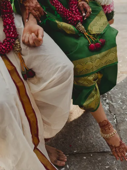 A close-up of the couple's attire and mehendi-adorned feet, showcasing the rich details of a traditional wedding.