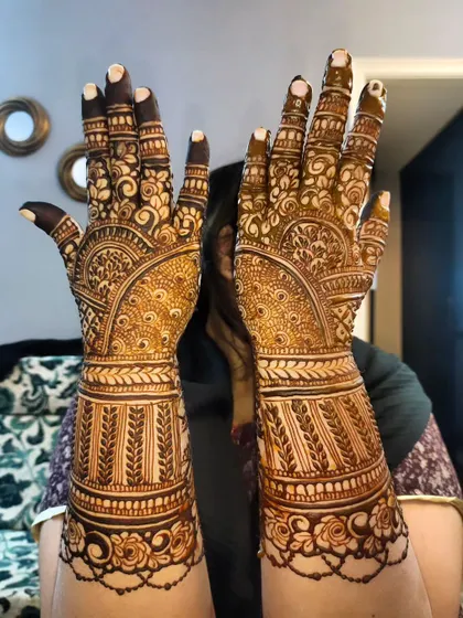 This bridal design features bands of leafy patterns on the forearm and detailed work on the hands.