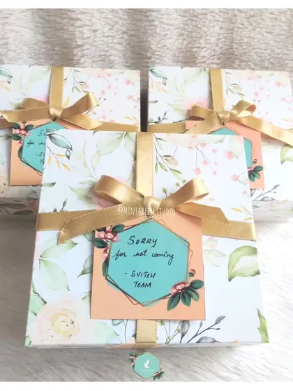 A set of "Sorry" gift boxes with a lovely floral pattern and gold ribbons. The thoughtful packaging and personalized tag help convey genuine sentiments and show you care, even when you can't be there in person.