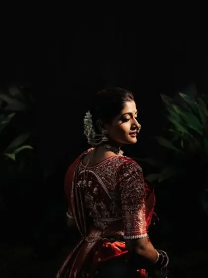 A dramatic, low-key portrait of the bride, with light just catching her profile against a dark background.