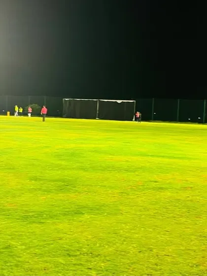 The vibrant green of the outfield under the bright floodlights creates a stunning visual and an ideal setting for night cricket.