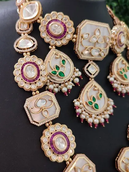 A close-up view revealing the delicate enamel painting and the sparkle of the surrounding stones. This set is a true work of art available for rent.
