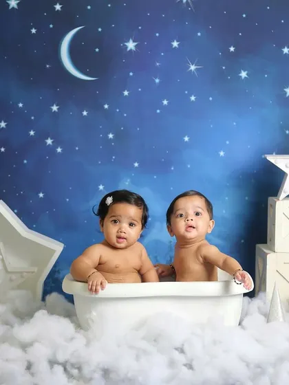 Twin babies enjoying a bubble bath in the stars. This creative setup is perfect for a magical and memorable twin photoshoot.