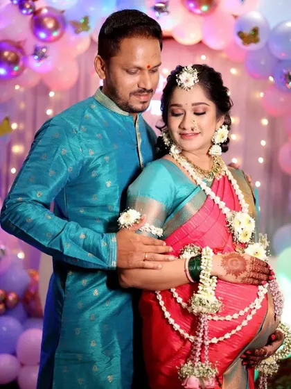 Capturing the joy and anticipation of new parents. The mom-to-be's look is complete with a beautiful saree drape that is comfortable for her, glowing makeup, and traditional flower jewelry, making her feel special on her big day.