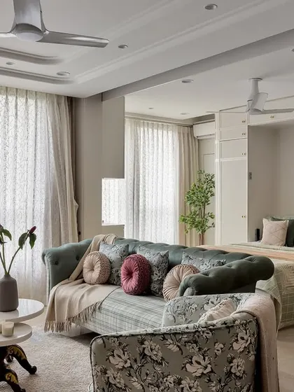 This living area is styled for comfort and elegance. The floral-patterned seating, layered throws, and soft lighting create a cozy atmosphere perfect for relaxing or hosting guests.