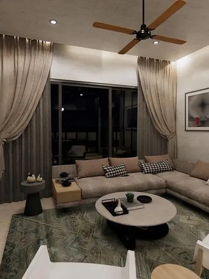 A cozy family lounge concept with a large L-shaped sofa and soft, textured curtains. The design is perfect for relaxing and watching movies, with a dark feature wall to enhance the viewing experience.