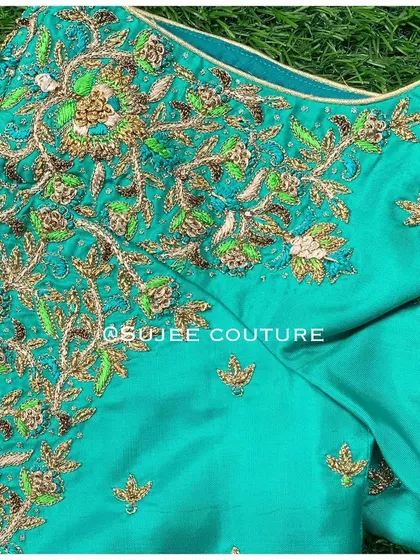 The neckline detail of the teal tree-of-life blouse. The intricate zardozi work creates a lush, garden-like effect on the rich silk fabric.