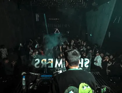 A view from behind the decks at Shimmers, with the crowd fully immersed in the music.