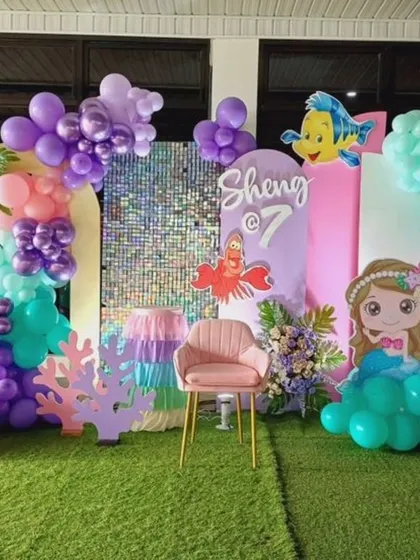 An elaborate mermaid-themed party with multiple character cutouts, a shimmer wall, and an under-the-sea vibe.