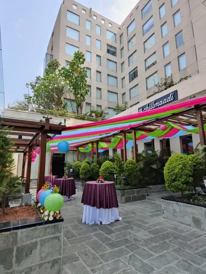 The outdoor space for the 'Colour Pop' brunch was decorated with bright fabric drapes and paper lanterns. This created a festive, multi-colored canopy that transformed the venue and enhanced the celebratory mood.