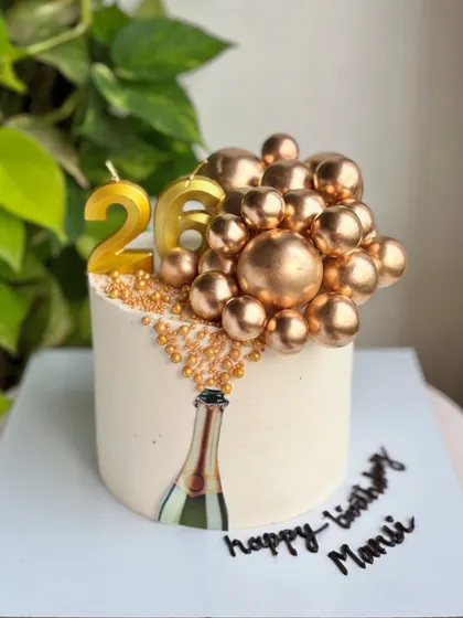 The full champagne-popping cake, complete with a personalized "Happy Birthday Mansi" message.