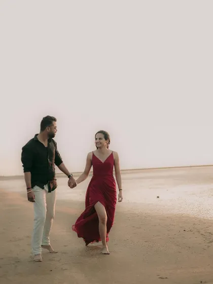 A wide shot of the couple on the beach, creating a sense of space and tranquility in their pre-wedding portrait.