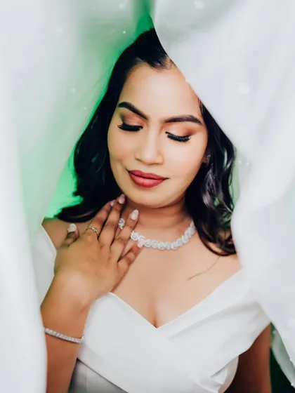 A creative shot with the veil creating a beautiful, soft frame. Her makeup looks absolutely flawless and ethereal.