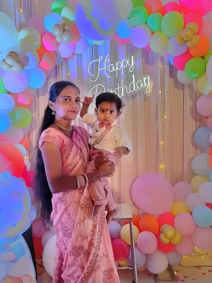 The mother and birthday boy posing against the vibrant, multi-colored balloon arch. We use high-quality balloons to create full and colorful arrangements that look great in photos.