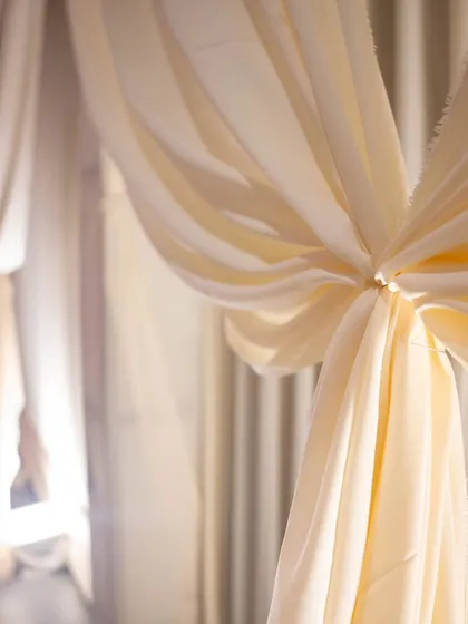 A close-up of the beautifully draped fabric backdrop, a simple yet effective way to add texture and sophistication to an event space.