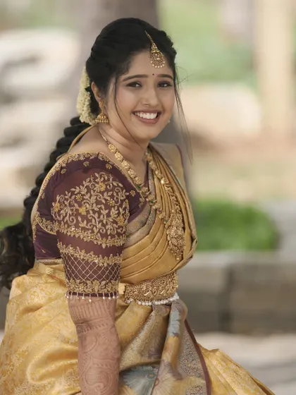A radiant welcome look for the bride Tejeshwini. Her golden silk saree is complemented by warm, glowing makeup and a beautifully detailed traditional hairstyle.