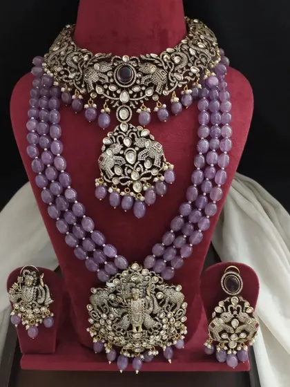 A complete bridal set in a beautiful lavender shade. This Victorian collection includes a choker, two long necklaces, and earrings, all designed to be worn together.