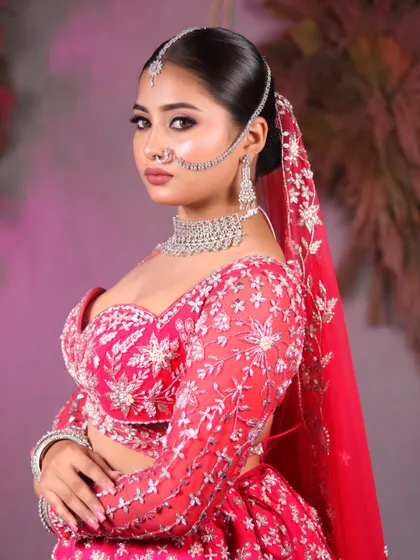 A regal bridal look in pink. The detailed embroidery on the lehenga is complemented by sharp, clean makeup and a traditional nath.
