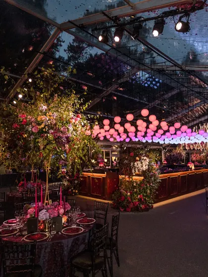 A moody, dramatic Sangeet inspired by the romance of Bridgerton. This setup in the British countryside features a clear-span marquee, lavish floral arrangements, and custom lighting to create a truly immersive, high-energy atmosphere.