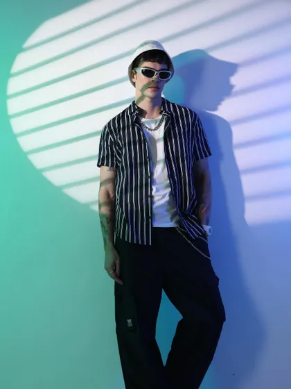 A full-body shot of the cyberpunk look, showing how the simple outfit is transformed by the lighting and accessories. The styling is minimal to let the art direction shine.