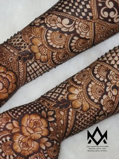 A view of the forearms, highlighting the floral and geometric patterns.