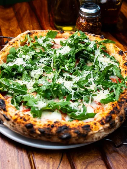 Rucola magic. Our Grana e Rucola pizza is a classic topped with fresh arugula and Grana Padano.