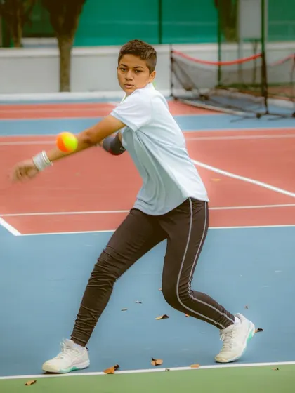 This young athlete shows excellent form and concentration during an orange ball drill. Our coaching focuses on building a strong technical base, which is essential for long-term development in tennis.